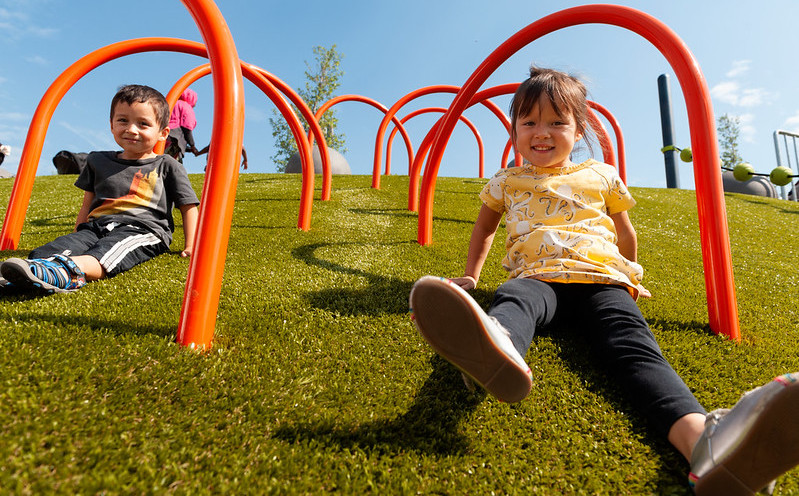 kids-playing-on-playground-grass-2 Kids playing on Playground Grass synthetic turf by ForeverLawn at Yesler Park in Seattle