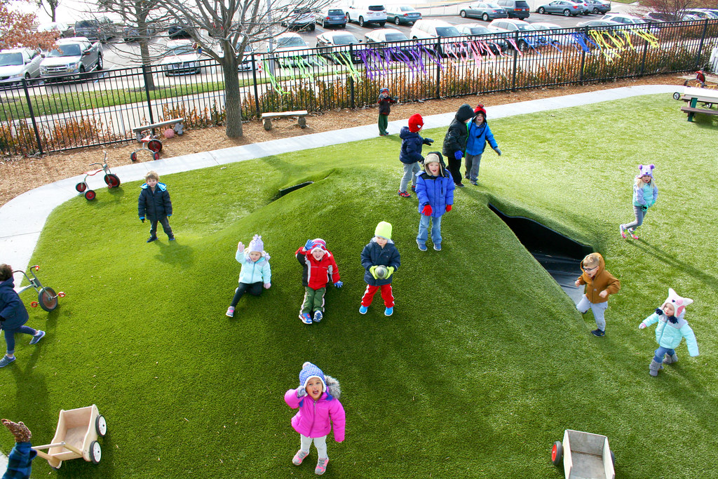kids-playing-waving-on-playground Kids playing and waving on Playground Grass synthetic turf