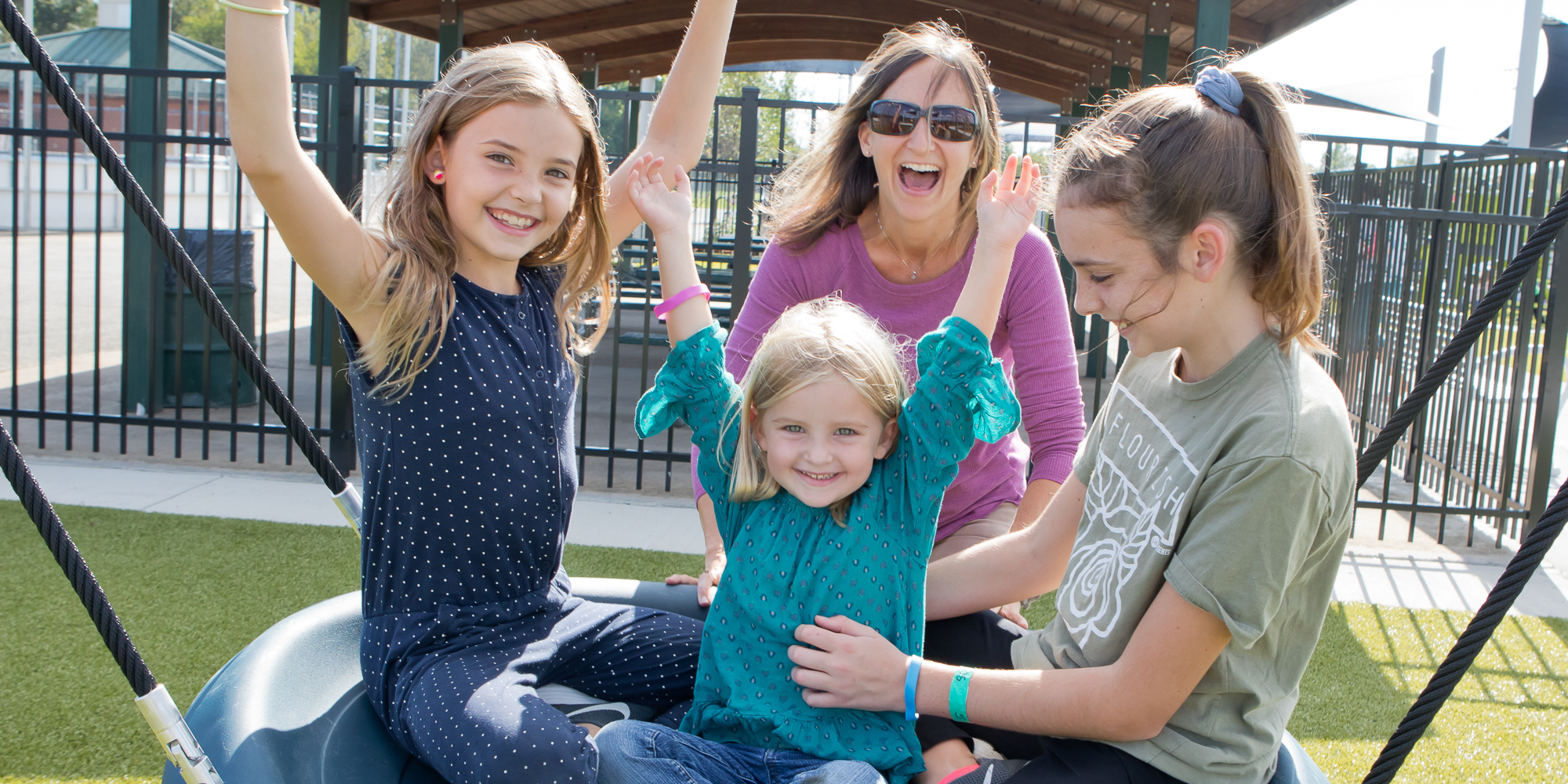 mom-kids-on-swing Mom and kids playing on Playground Grass synthetic turf by ForeverLawn