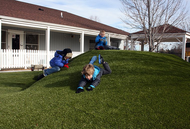 Kids playing on Playground Grass Ultra by ForeverLawn at Security Benefit Academy child care center in Topeka, Kansas