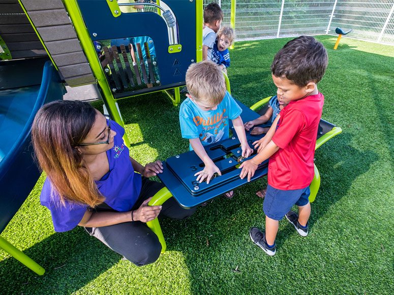 Children playing on Smart Start Child Care playground featuring Playground Grass by ForeverLawn